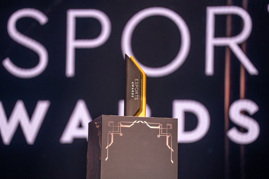 An esports awards trophy on stage.